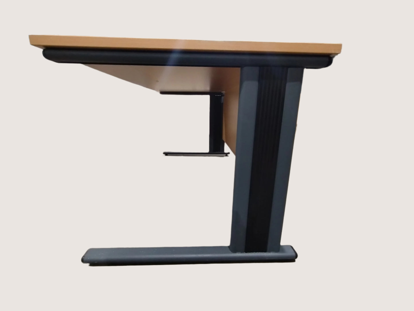 Desk with a black base and wooden top in an indoor setting